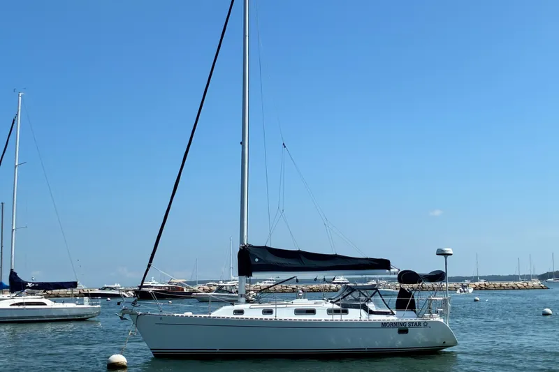 The Image of Sailboat "Morning Star," Freedom 35, 1996 model, docked in a marina under clear blue skies. - 1
