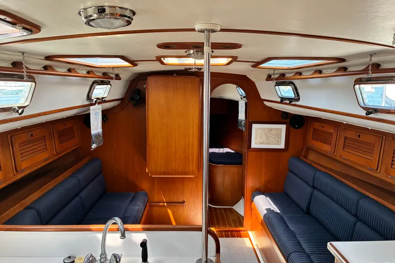 Slide: The Image of Interior of a 1996 Freedom 35 sailboat with wood paneling and blue seating. - 2