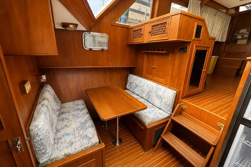 Slide: The Image of 1986 Marine Trader Labelle interior with wooden dining area and cushioned seating. - 17