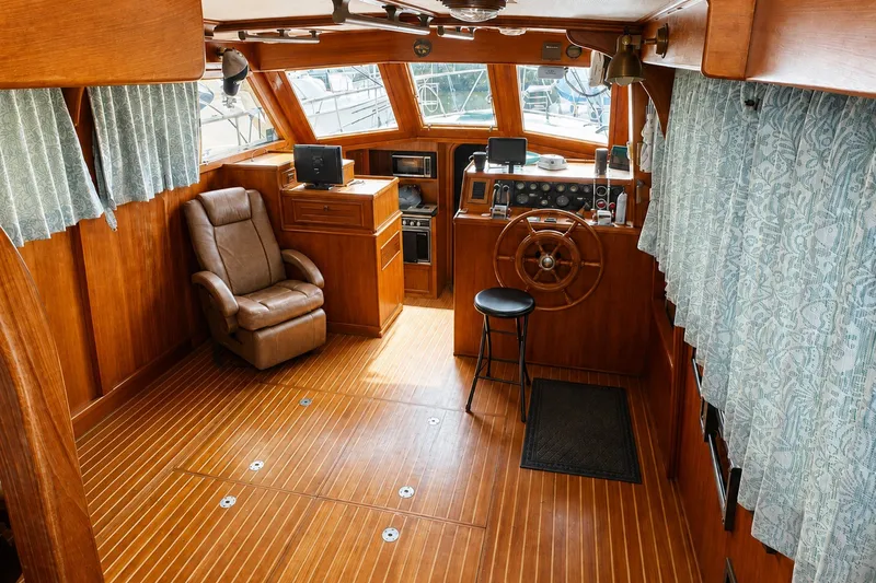 Slide: The Image of 1986 Marine Trader Labelle yacht interior with wooden helm, leather chair, and nautical decor. - 8