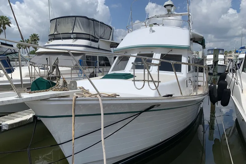Slide: The Image of 1986 Marine Trader Labelle yacht docked at marina under cloudy sky. - 2