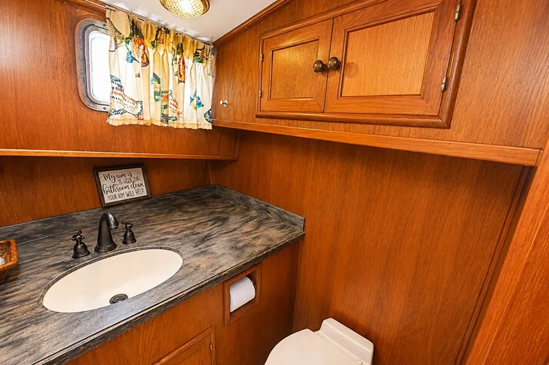 Slide: The Image of 1986 Marine Trader Labelle yacht bathroom with wood cabinetry and marble countertop. - 24