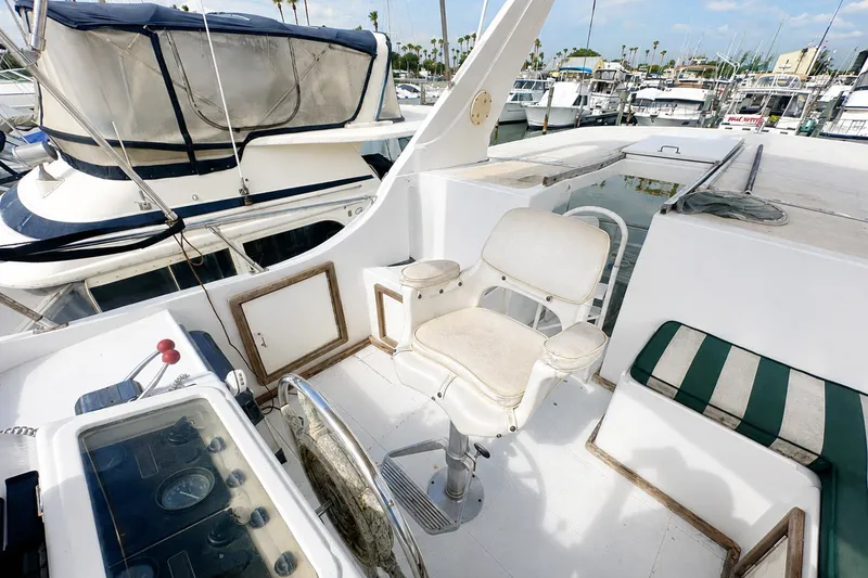Slide: The Image of 1986 Marine Trader Labelle yacht helm with seating, docked in a marina. - 7