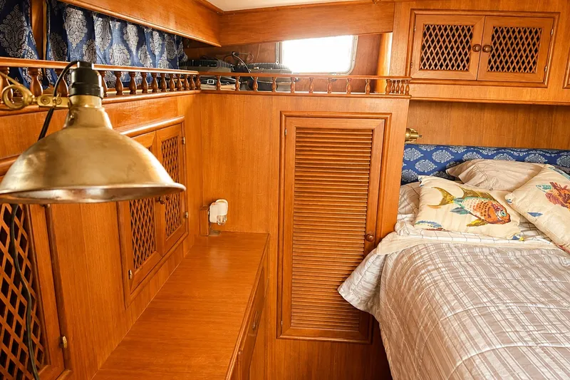 Slide: The Image of Cozy 1986 Marine Trader Labelle cabin with wooden interior and nautical-themed bedding. - 27