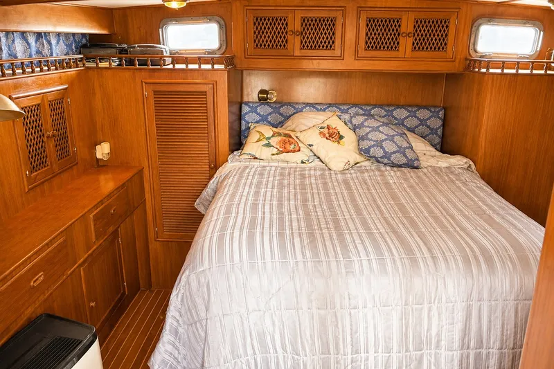 Slide: The Image of Cozy bedroom interior of 1986 Marine Trader Labelle yacht with wood paneling and floral pillows. - 25