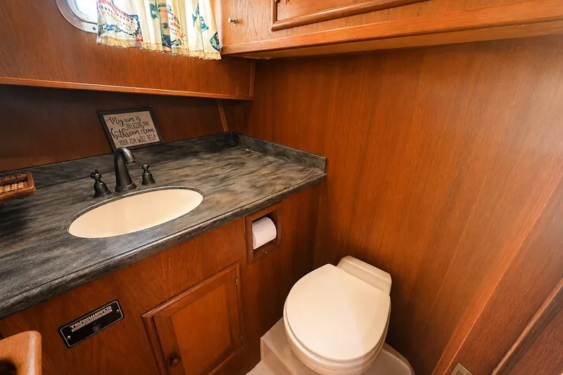 Slide: The Image of 1986 Marine Trader Labelle bathroom with wood paneling, sink, and toilet. - 23