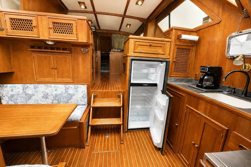 Slide: The Image of Interior of 1986 Marine Trader Labelle yacht with wood finish, open fridge, and dining area. - 16