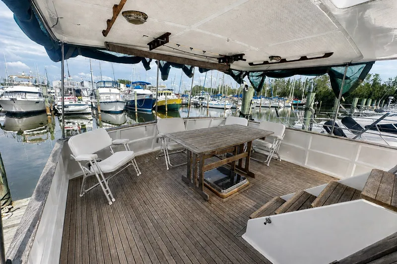 Slide: The Image of 1986 Marine Trader Labelle yacht deck with wooden table and chairs, docked at marina. - 3