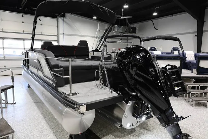 Slide: The Image of 2026 Evotti 723CS pontoon boat with sleek black motor in showroom. - 5