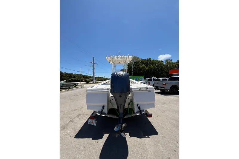 Slide: The Image of 2017 Robalo 246 Cayman boat with outboard motor, parked outdoors under clear blue sky. - 7