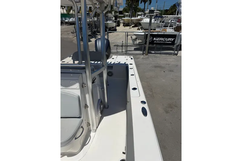 Slide: The Image of 2017 Robalo 246 Cayman boat interior with seating and rod holders, docked at a marina. - 11