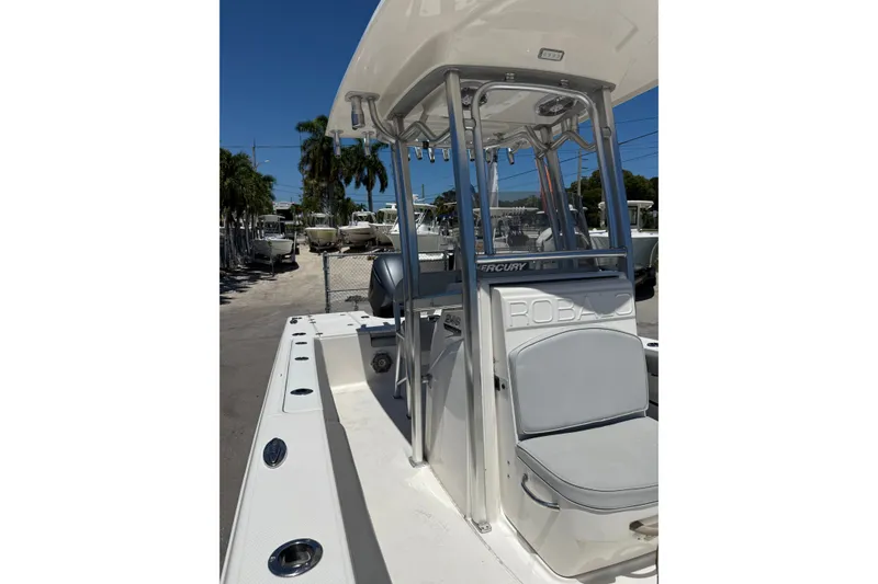 Slide: The Image of 2017 Robalo 246 Cayman boat with T-top and seating, parked outdoors. - 8