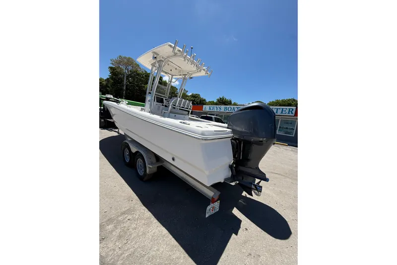 Slide: The Image of 2017 Robalo 246 Cayman boat on trailer, parked outdoors under clear blue sky. - 4
