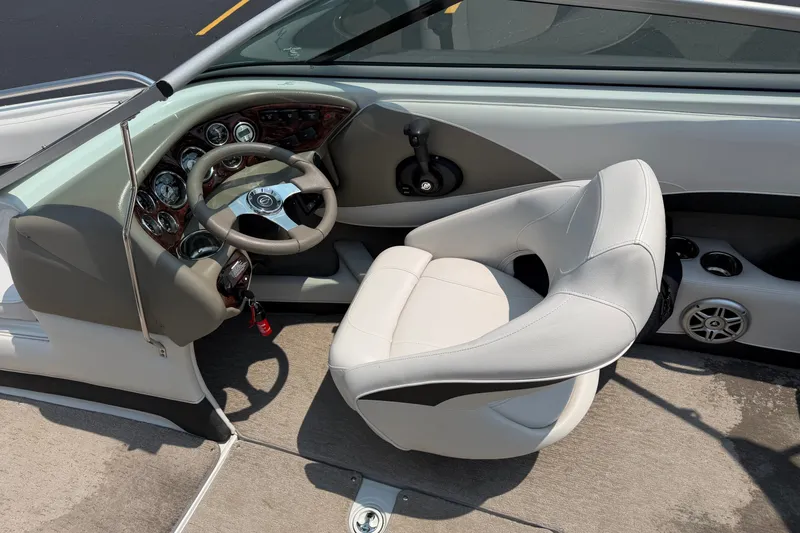 Slide: The Image of Interior of a 2015 Crownline 21 SS boat, featuring a sleek steering wheel and comfortable seating. - 17