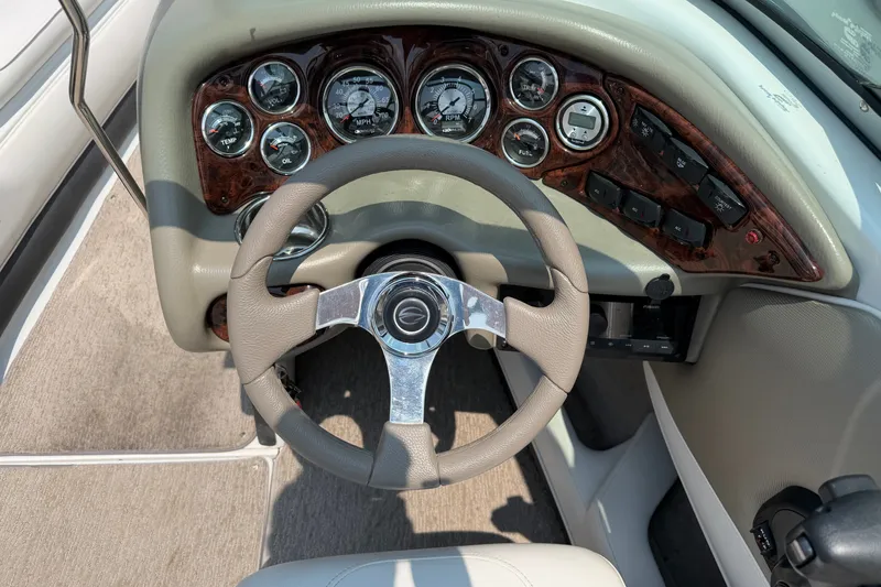 Slide: The Image of Steering wheel and dashboard of 2015 Crownline 21 SS boat with gauges and controls. - 13