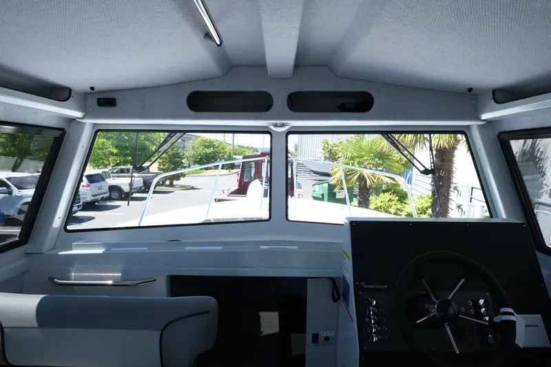 Slide: The Image of Interior view of 2026 KingFisher 23 XAC boat cockpit with steering wheel and windows. - 14