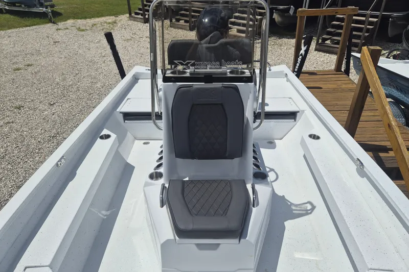 Slide: The Image of 2026 Xpress H22 Bay boat interior with gray seating and steering console. - 20