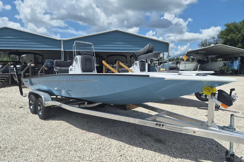 The Image of 2026 Xpress H22 Bay boat on trailer under blue sky. - 1