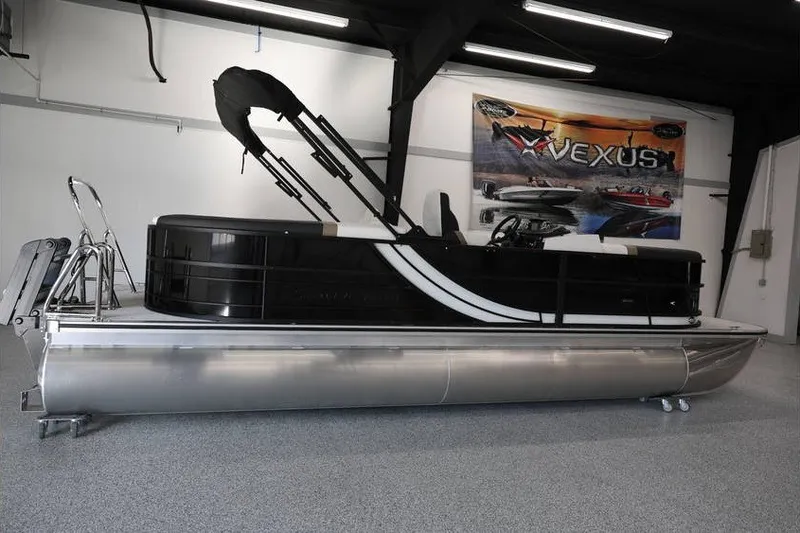 Slide: The Image of 2026 South Bay 224 RS Tritoon boat in showroom, sleek black design. - 3