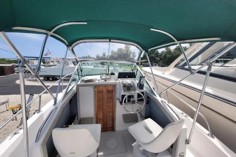 Slide: The Image of 1990 Grady-White Overnighter 204 boat interior with steering wheel and canopy. - 19