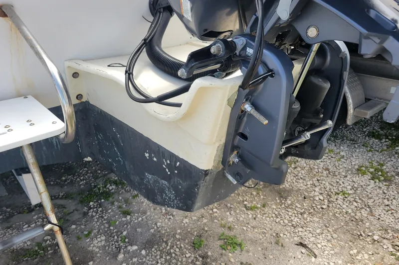 Slide: The Image of 1990 Grady-White Overnighter 204 boat engine and ladder detail on gravel surface. - 7