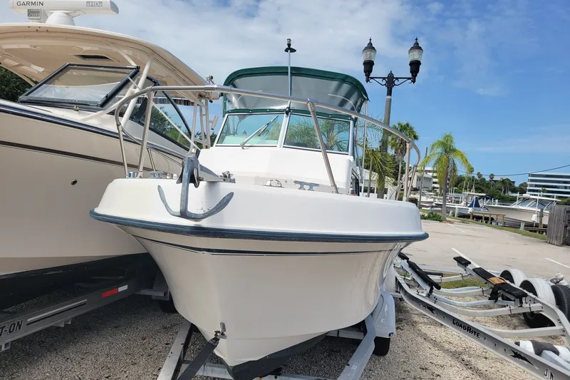 Slide: The Image of 1990 Grady-White Overnighter 204 boat on trailer, marina background. - 3