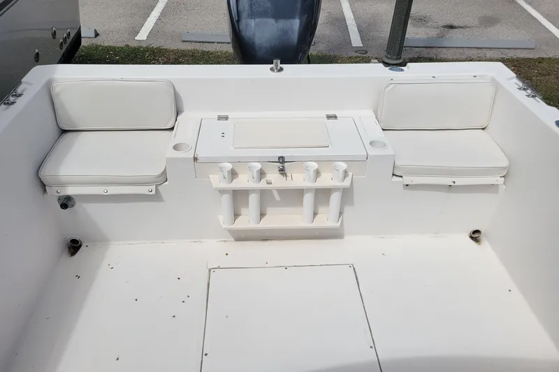 Slide: The Image of 1990 Grady-White Overnighter 204 boat interior with white seating and rod holders. - 14