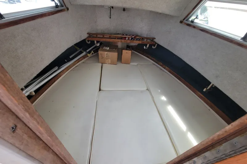 Slide: The Image of Interior cabin of a 1990 Grady-White Overnighter 204 boat, featuring storage and seating. - 15