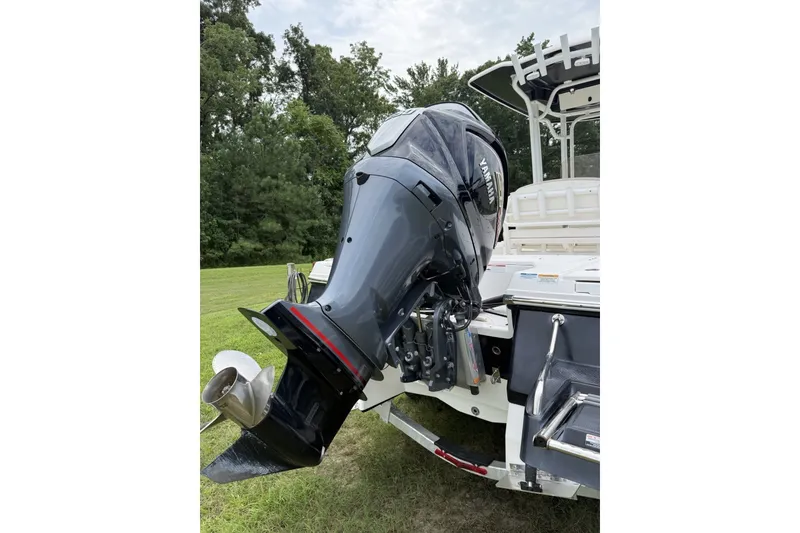 Slide: The Image of 2022 Robalo 226 Cayman boat with Yamaha outboard motor, parked on grass. - 9