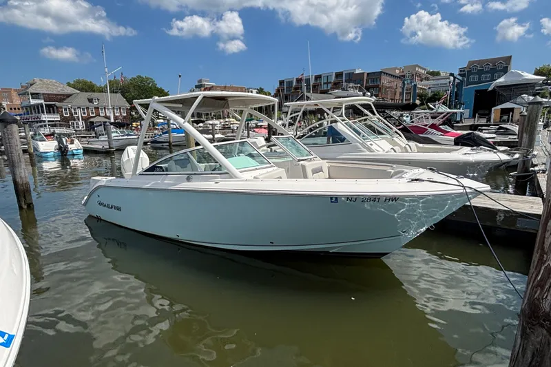 The Image of 2026 Sailfish 236 DC boat docked in a marina under a clear blue sky. - 0