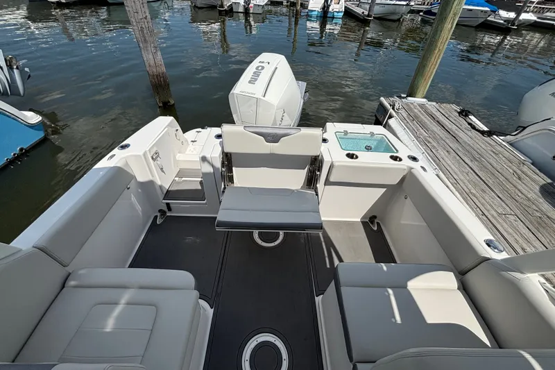 Slide: The Image of 2026 Sailfish 236 DC boat interior with seating and motor at dock. - 9