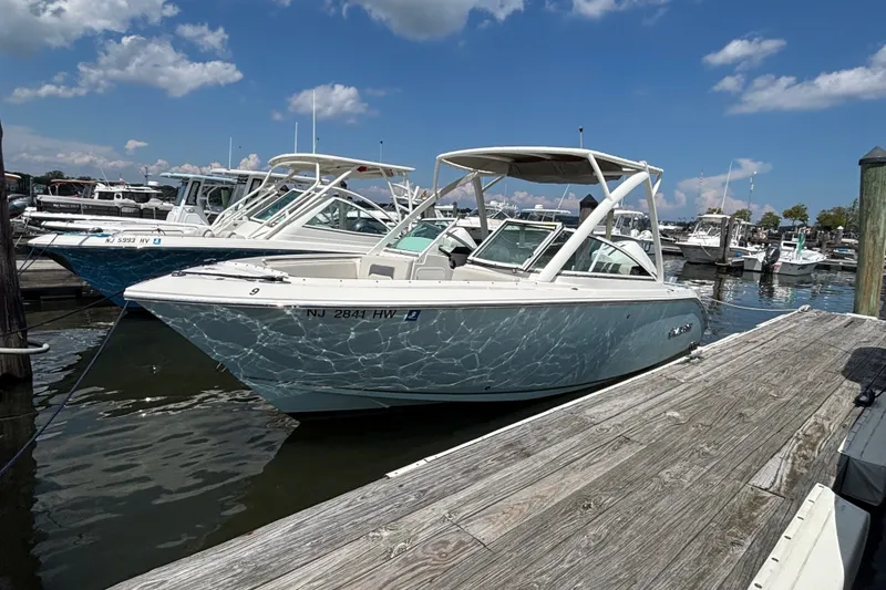 Slide: The Image of 2026 Sailfish 236 DC boat docked at marina under clear blue sky. - 1