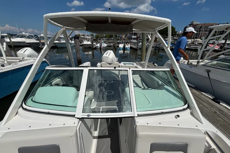 Slide: The Image of 2026 Sailfish 236 DC boat docked at marina under clear blue sky. - 6
