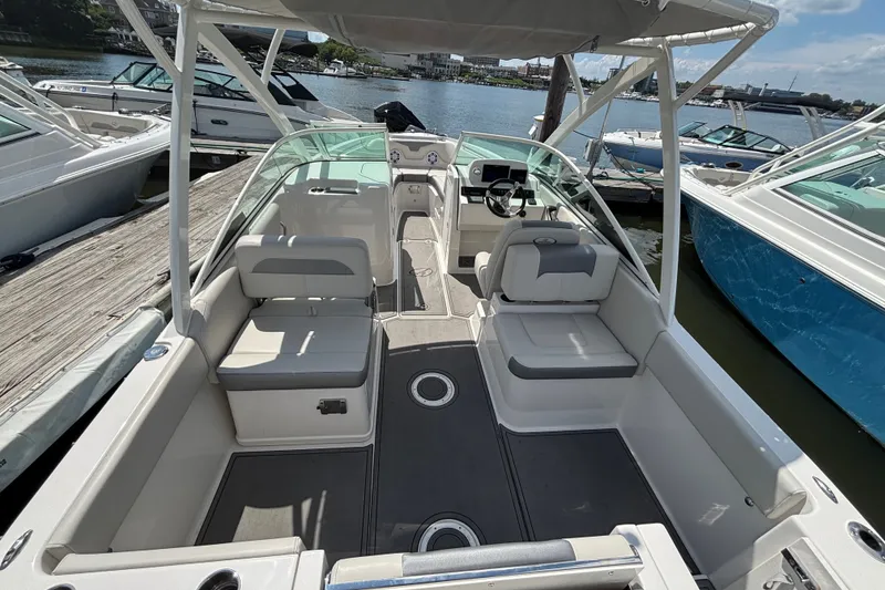 Slide: The Image of 2026 Sailfish 236 DC boat interior with seating and steering, docked by the water. - 13