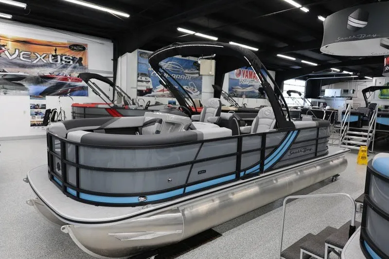Slide: The Image of 2026 South Bay 224 RS 2.75 Hybrid Arch pontoon boat displayed in showroom. - 2