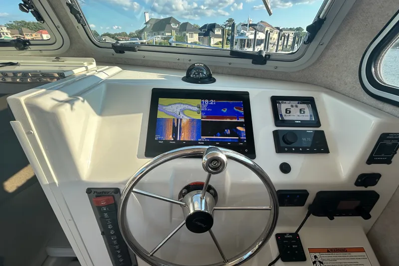Slide: The Image of 2021 Parker 2520 XLD Sport Cabin helm with navigation screens and steering wheel. - 9