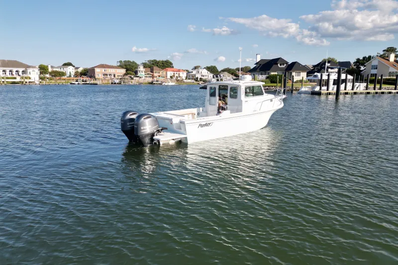 Slide: The Image of 2021 Parker 2520 XLD Sport Cabin boat on calm water near residential area. - 15