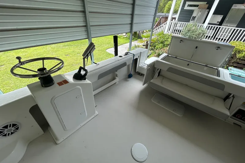 Slide: The Image of 2021 Parker 2520 XLD Sport Cabin boat interior with steering wheel and seating area. - 12