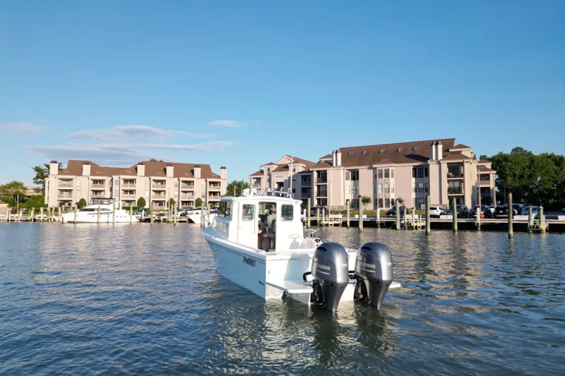 Slide: The Image of 2021 Parker 2520 XLD Sport Cabin boat on water near waterfront buildings. - 14