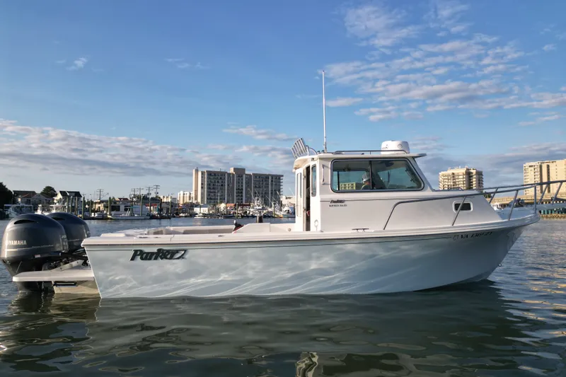 The Image of 2021 Parker 2520 XLD Sport Cabin boat on calm water, cityscape background. - 1
