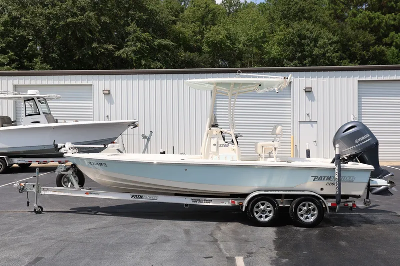 Slide: The Image of 2017 Pathfinder 2200 TRS boat on trailer, parked outdoors near storage facility. - 6