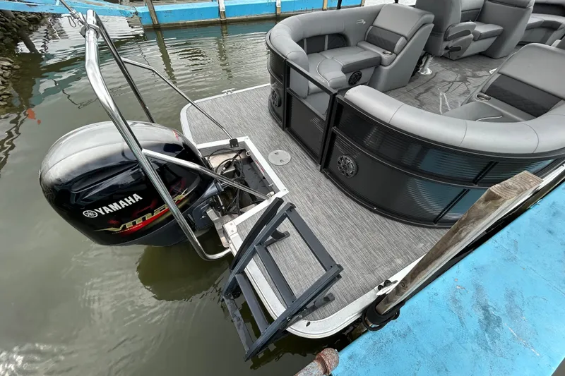 Slide: The Image of 2020 Bennington 23 SX pontoon boat with Yamaha motor, docked on calm water. - 12