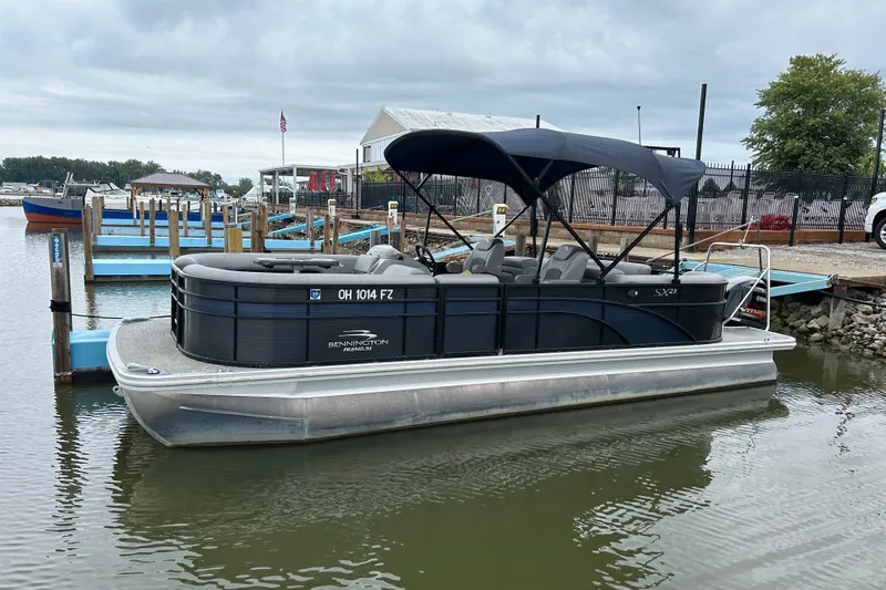 The Image of 2020 Bennington 23 SX pontoon boat docked at a marina under cloudy skies. - 0