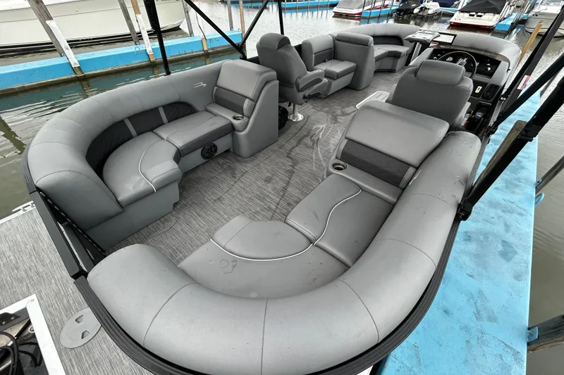 Slide: The Image of The image shows the spacious interior of a Bennington 23 SX pontoon boat with gray upholstery. - 11