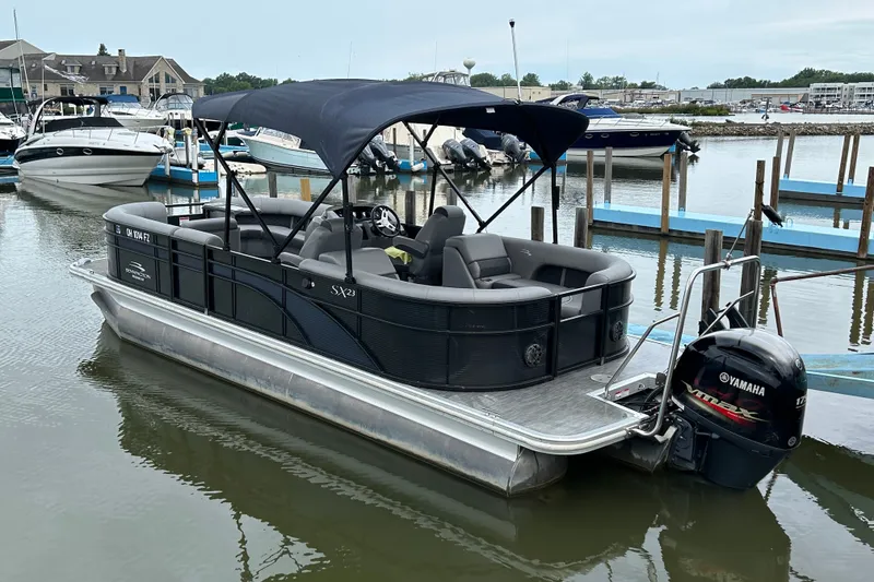 Slide: The Image of 2020 Bennington 23 SX pontoon boat docked with Yamaha outboard motor. - 1