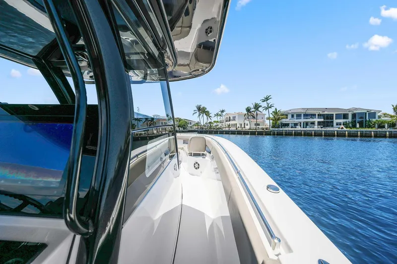 Slide: The Image of 2024 Sportsman Open 352 Center Console boat cruising on a sunny waterfront. - 35