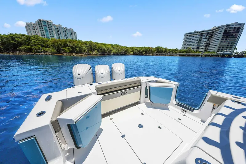 Slide: The Image of 2024 Sportsman Open 352 Center Console boat on serene water with modern buildings in background. - 24