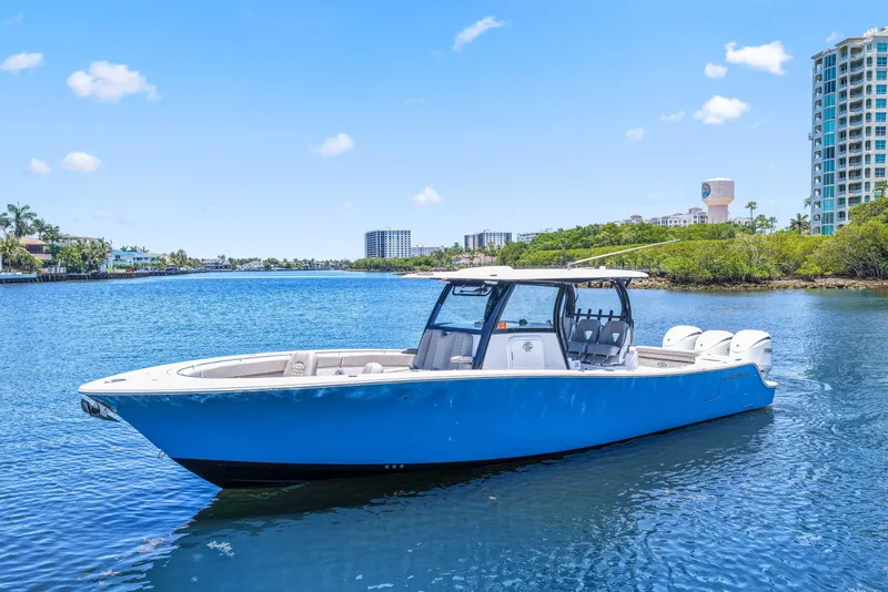 Slide: The Image of 2024 Sportsman Open 352 Center Console boat on a sunny waterfront. - 1