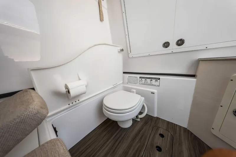 Slide: The Image of 2024 Sportsman Open 352 Center Console boat bathroom interior with toilet and storage. - 37