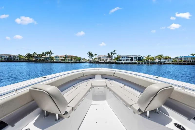 Slide: The Image of 2024 Sportsman Open 352 Center Console boat on calm water, luxury waterfront homes in background. - 32